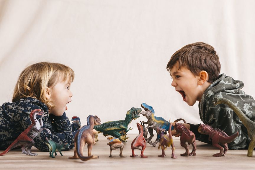 Kinder spielen mit Dinosauriern